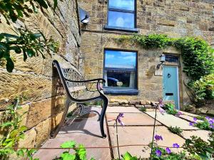 a bench sitting in front of a brick building at Finest Retreats - Ingleside Cottage in Whitby