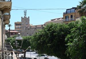 una strada cittadina con una torre dell'orologio in lontananza di Civico 10 Deluxe Room a Licata