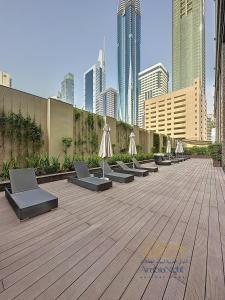a row of chairs with umbrellas on a wooden deck at La Casa By Arabian Nights - City View - Bespoke Design in Dubai