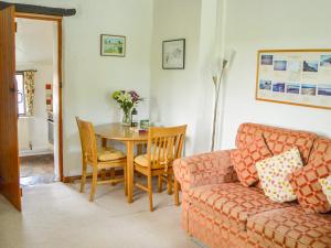 a living room with a table and a couch at Barley Cottage in Bideford