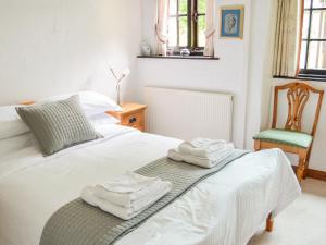 a bedroom with a bed with towels on it at Barley Cottage in Bideford