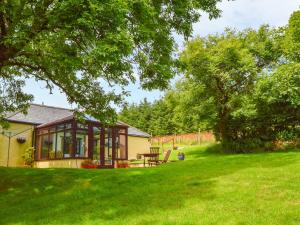 a small house in a yard with a green lawn at Barley Cottage in Bideford