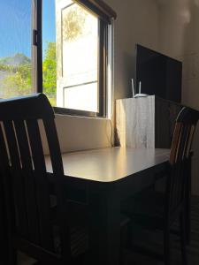 a dining room table with two chairs and a window at Avana Hills Boracay Prime Economy Suite in Boracay