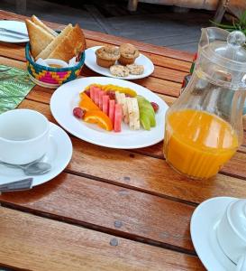een tafel met borden en een kan sinaasappelsap bij Sky Beach Hotel in Wakiso