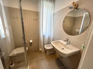 a bathroom with a sink and a toilet and a mirror at Lodge 99 in Pescara