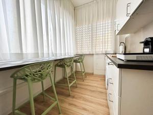 a kitchen with green chairs and a counter top at Lodge 99 in Pescara