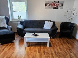 a living room with a couch and a coffee table at Ingrids Ferienwohnung in Erfde