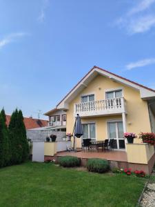 a house with a patio and an umbrella at Modern & cozy house with 3 bed rooms and garden in Prievoz