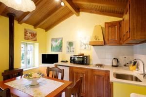 cocina con mesa, fregadero y encimera en Villa nel Borgo en Borgomaro