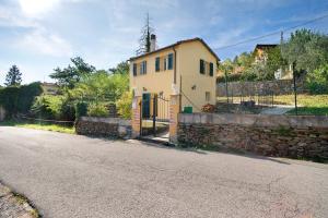 una pequeña casa amarilla al lado de una calle en Villa nel Borgo en Borgomaro