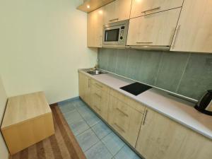 a kitchen with wooden cabinets and a microwave at Fantastic Waw - Z6 Room - 204A in Warsaw