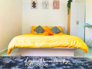 1 dormitorio con 1 cama con edredón de naranja en Laguna Damai Homestay PortDickson - "PoolView & BeachNearby" en Port Dickson