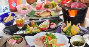 una mesa con varios platos de comida y bebida en Kotobuki, en Yamanouchi