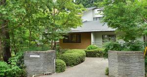 una casa con dos barreras de piedra frente a un patio en Kotobuki, en Yamanouchi