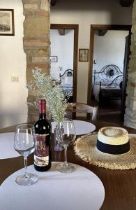 una botella de vino sentada en una mesa con dos copas en Torre di Celle, en Monte Santa Maria Tiberina