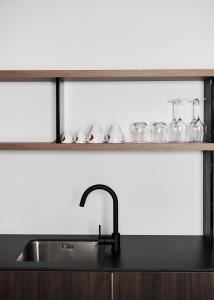 a kitchen sink and shelf with glasses on it at Alinea Primo Historic Center in Limassol