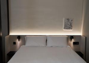 a bedroom with a white bed with two pillows at Alinea Primo Historic Center in Limassol