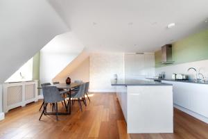 a kitchen with a table and chairs in a room at The South Hampstead Collection in London