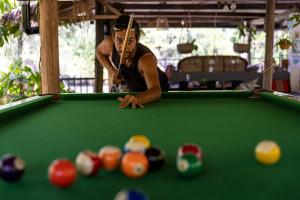 a man playing a game of pool with a cue at Kampot Cabana in Kampot