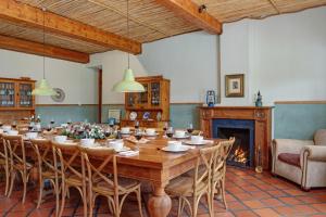 a large wooden table in a room with a fireplace at Buccara Wildlife Reserve in Graaff-Reinet
