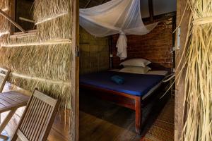 Habitación pequeña con cama y mosquitera. en Kampot Cabana en Kampot