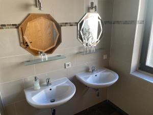 Baño con 2 lavabos y espejo en Hotel Klement, en Zehdenick