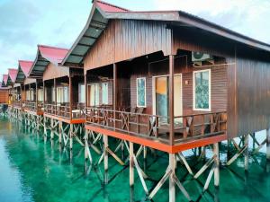 a row of cottages on the water at Derawan Fisheries Cottage 