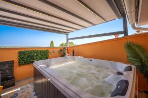 a large bath tub in a room with a large window at Venus Holiday House with Pool in Banjole