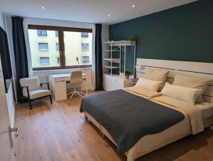 1 dormitorio con cama, escritorio y ventana en Goldstadt Apartments en Pforzheim