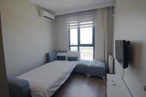 Habitación pequeña con cama y TV. en Charming 3bdr Apartment For A Memorable Stay, en Basaksehir