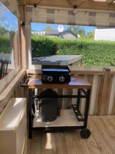 a device on a cart in a covered porch at - Mobilhome Camping Les Charmettes - Fun pass non inclus - in Les Mathes