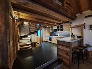 a kitchen with wooden ceilings and a island in a room at Chalet Augustin in Vaujany