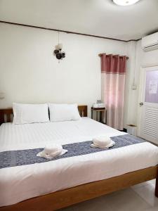 um quarto com uma cama com dois chapéus em กาลครั้งหนึ่ง ณ เชียงคาน (Once Upon A time) em Chiang Khan