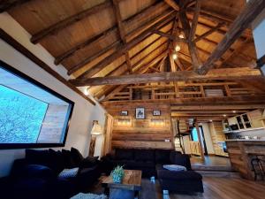 a living room with a couch and a wooden ceiling at Chalet Augustin in Vaujany