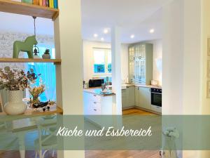 een keuken met witte kasten en een tafel. bij Customflats Erfurt - Tiefgarage - frisch renoviert in Erfurt
