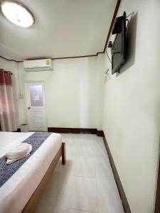 um quarto com uma cama e uma televisão na parede em กาลครั้งหนึ่ง ณ เชียงคาน (Once Upon A time) em Chiang Khan