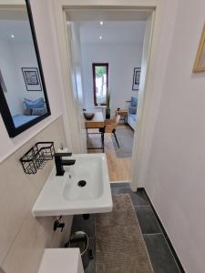 baño con lavabo blanco y sala de estar. en 1 Bedroom im Zentrum, en Schleswig