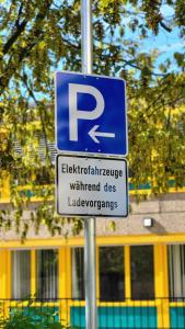 una señal de estacionamiento en un poste frente a un edificio en Central Hotel Eschborn, en Eschborn