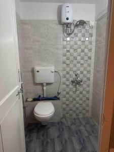 a small bathroom with a toilet and a shower at Sage : Private Studio Room in Koregaon Park in Pune