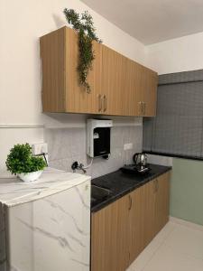a kitchen with wooden cabinets and a white refrigerator at Sage : Private Studio Room in Koregaon Park in Pune