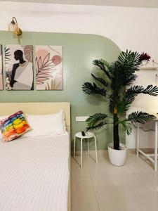 a bedroom with a bed and a palm tree in it at Sage : Private Studio Room in Koregaon Park in Pune