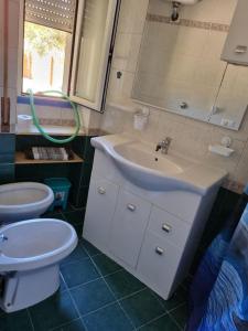 łazienka z białą umywalką i toaletą w obiekcie La casetta all'angolo w mieście Passo Oscuro