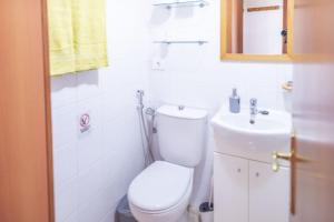 a white bathroom with a toilet and a sink at Lightbooking El Burrero in Ingenio