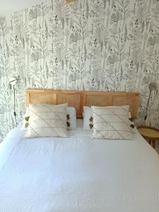 - une chambre avec un lit et un papier peint floral dans l'établissement Mas de Brun Confort, à Puget-Ville