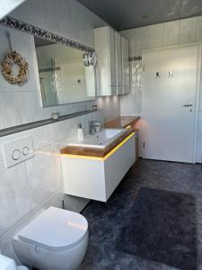 y baño con aseo, lavabo y espejo. en Haus Olga en Blankenheim