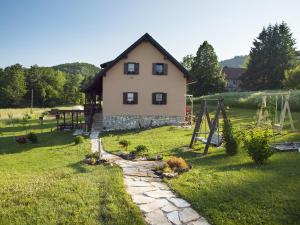 a house with a playground in front of a yard at House Izvor in Jezerce