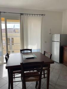 een keuken met een tafel en stoelen en een koelkast bij Casa Victoria in Golfo Aranci
