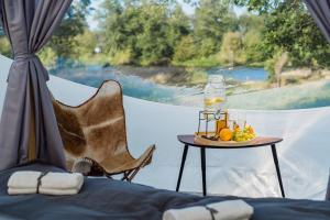 a table with a drink on it next to a window at Golden Glamping nad Narwią in Lubiel Stary