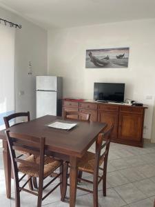 een keuken met een houten tafel met stoelen en een koelkast bij Casa Victoria in Golfo Aranci