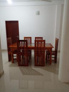 a dining room with a wooden table and chairs at Minsara Villa in Hikkaduwa